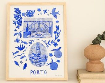 May include: A blue and white watercolor illustration of the city of Porto, Portugal. The illustration features a bridge, a church, and a variety of other details. The illustration is framed and hanging on a white wall.