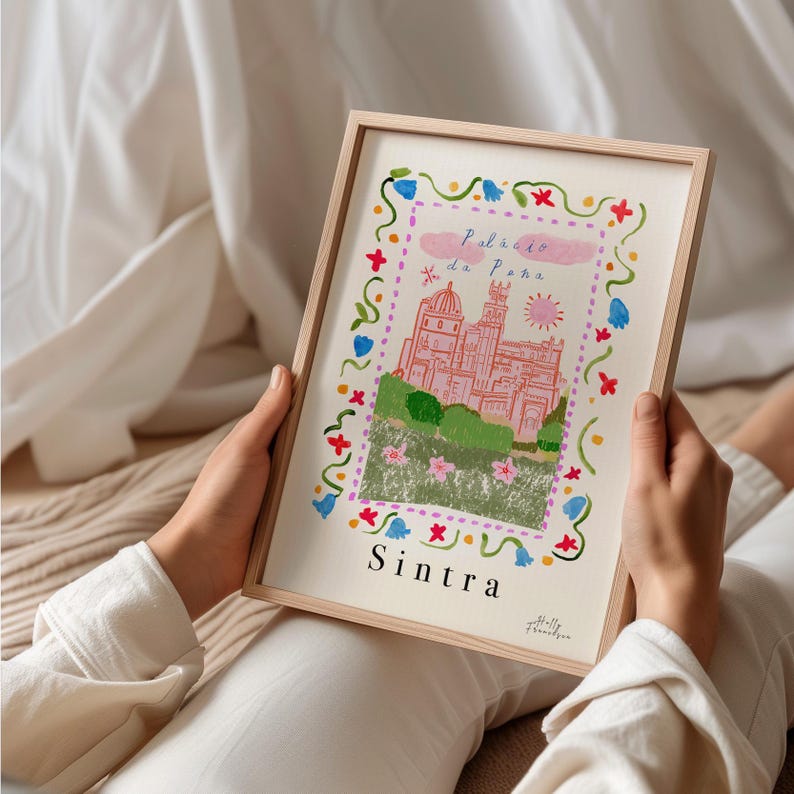 May include: A framed print of a pink castle with a green roof and a blue sky. The castle is surrounded by a border of flowers in various colors. The text "Pal&aacute;cio da Pena" and "Sintra" are printed below the image.