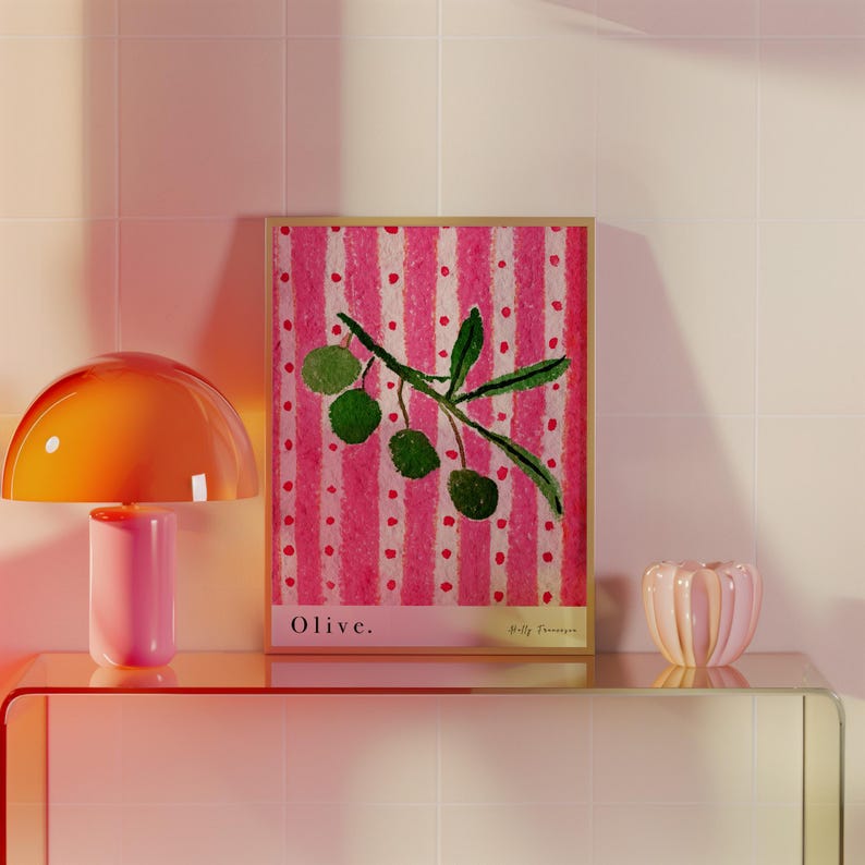 Puede incluir: Una impresi&oacute;n enmarcada de una pintura de una rama de olivo con aceitunas verdes sobre un fondo a rayas rosa y blanco. La impresi&oacute;n se titula "Olive."
