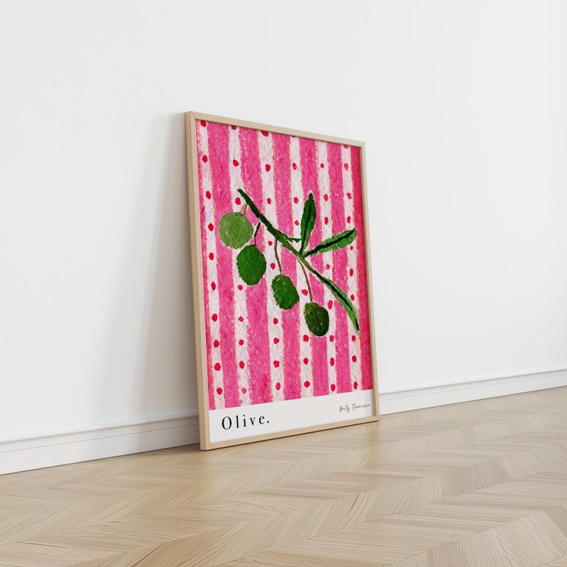 Puede incluir: Una impresi&oacute;n enmarcada de una rama de olivo verde con fondo a rayas rosa y blanco. La impresi&oacute;n tiene la palabra "Olive." en la parte inferior y el nombre del artista "Holly Francesca" en una fuente m&aacute;s peque&ntilde;a.