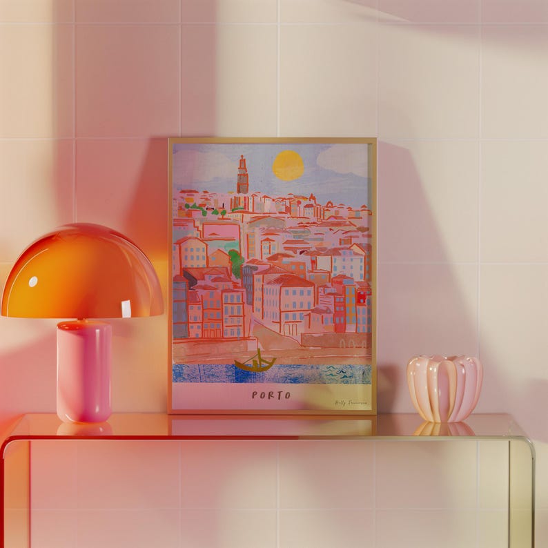 May include: A framed illustration of a cityscape with a bright yellow sun in the sky. The city is painted in shades of pink, blue, and green. The text "PORTO" is printed at the bottom of the illustration.