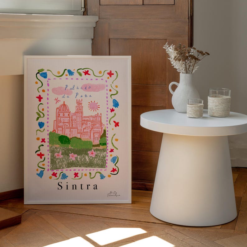 May include: A framed illustration of the Palacio da Pena in Sintra, Portugal. The illustration is in a colorful, cartoon style with a pink castle, green trees, and a blue sky. The text "Palacio da Pena" and "Sintra" are written in a whimsical font.
