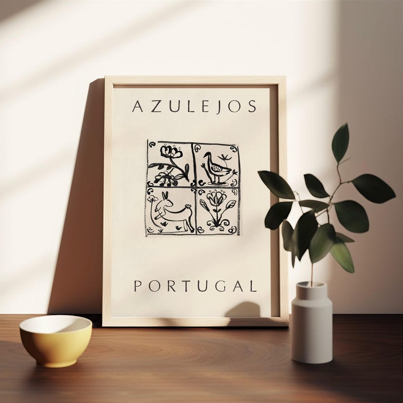 May include: A framed print with the word "AZULEJOS" at the top and "PORTUGAL" at the bottom. The print features a black and white illustration of four square tiles with different designs, including a bird, a rabbit, and flowers.
