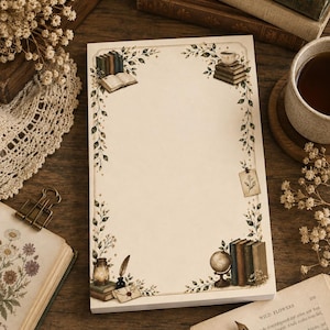 Può includere: Un blocco note rettangolare con un centro color crema e un bordo decorativo con illustrazioni di pile di libri, un mappamondo, una lanterna, una penna d'oca, una tazza da tè e viticci. Il design include piccole stelle e un'etichetta appesa.