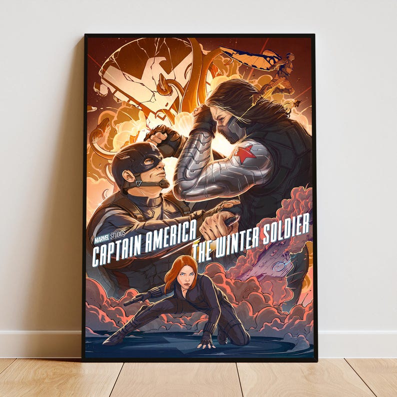 May include: A framed poster featuring Captain America, The Winter Soldier, and Black Widow. The artwork depicts a battle scene with Captain America and The Winter Soldier facing off, and Black Widow in a combat pose. The poster has a black frame.