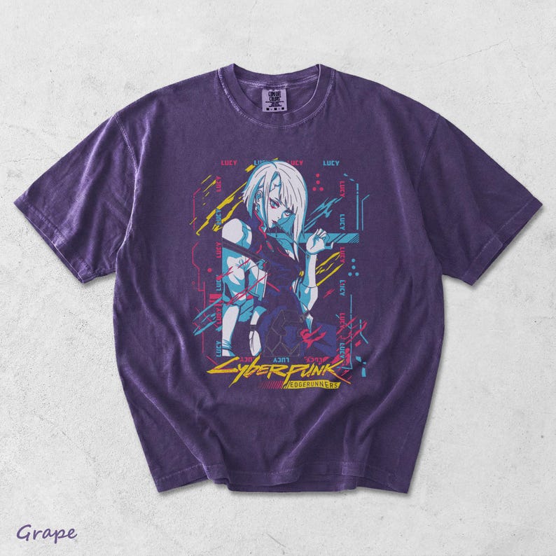 May include: A grape-coloured short-sleeve t-shirt featuring a graphic print of a white-haired character. The design includes the text "LUCY" repeated multiple times, along with "CYBERPUNK" and "EDGERUNNERS" in yellow and red lettering.