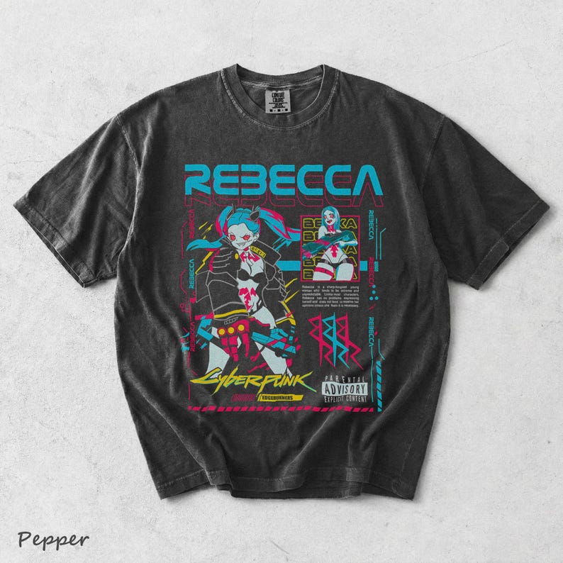 K&ouml;nnte beinhalten: Ein anthrazitfarbenes Kurzarm-T-Shirt mit einem Grafikdruck der Figur Rebecca aus Cyberpunk Edgerunners. Das Design enth&auml;lt leuchtend blauen, pinken und gelben Text sowie Illustrationen und ein Parental Advisory Explicit Content-Label.