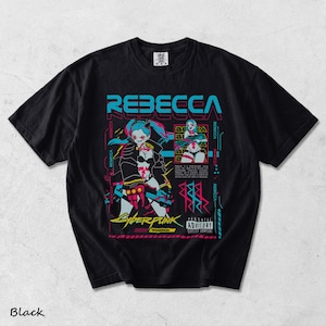 K&ouml;nnte beinhalten: Ein schwarzes Kurzarm-T-Shirt mit einem Grafikdruck der Figur Rebecca aus Cyberpunk Edgerunners. Das Design enth&auml;lt leuchtend blaue und rosa Akzente, den Text REBECCA und ein Parental Advisory Explicit Content-Etikett.