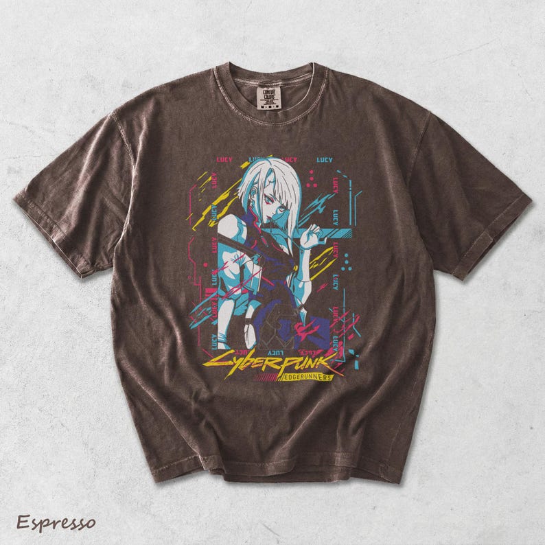 May include: An espresso-coloured short-sleeve t-shirt featuring a graphic print of the character Lucy from Cyberpunk Edgerunners. The design includes neon blue, pink, and yellow accents with the text Cyberpunk Edgerunners and the name Lucy.