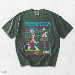 K&ouml;nnte beinhalten: Ein moosgr&uuml;nes Kurzarm-T-Shirt mit einem Grafikdruck der Figur Rebecca aus Cyberpunk Edgerunners. Das Design enth&auml;lt den Text REBECCA, CYBERPUNK EDGERUNNERS und ein Parental Advisory Explicit Content-Label in leuchtenden Farben.