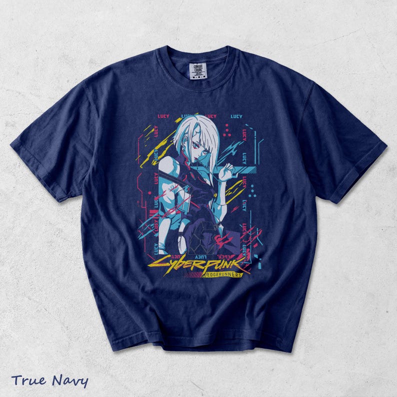 May include: A true navy blue short-sleeve t-shirt featuring a graphic print of the character Lucy from Cyberpunk Edgerunners. The design includes neon-coloured abstract lines, the repeated text Lucy, and the Cyberpunk Edgerunners logo in yellow.