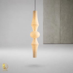 May include: A tall, cylindrical pendant light fixture with a ribbed, paper-like texture in a light beige color. The lamp features a symmetrical, stacked design with a central rounded bulbous section flanked by two tapered, elongated conical shapes.