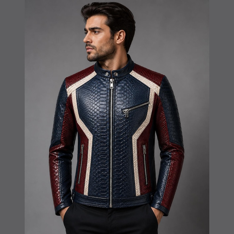 May include: A multi-colored jacket featuring a textured snakeskin pattern in navy blue, deep red, and cream. The garment has a stand-up collar with a snap button, a full-length silver metal zipper, and three zippered pockets on the front chest and sides.