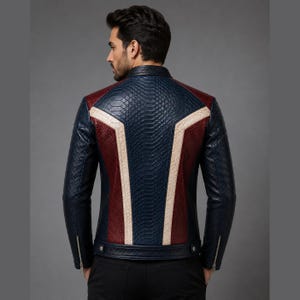 May include: A jacket featuring a textured snakeskin pattern in navy blue, deep red, and cream. The back displays a geometric panel design with a central navy blue section flanked by red panels and cream-colored stripes. It has long sleeves with zippers.