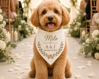 May include: A light brown curly-haired dog wearing a white triangular bandana. The bandana features the name Milo, the initials A & J, and the date September 20, 2026, printed in green text with a small pink heart and a floral wreath design.