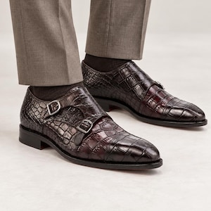 Man wearing dark chocolate brown croc embossed double monk strap shoes with tailored trousers for wedding, business and formal styling.