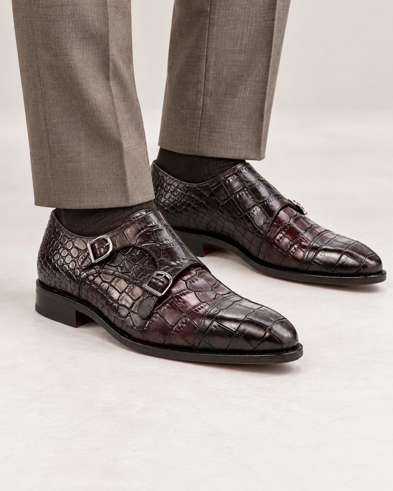Man wearing dark chocolate brown croc embossed double monk strap shoes with tailored trousers for wedding, business and formal styling.