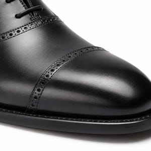 Men’s black cap toe Oxford shoes with structured toe seam, traditional lacing and sophisticated business dress shoe styling.