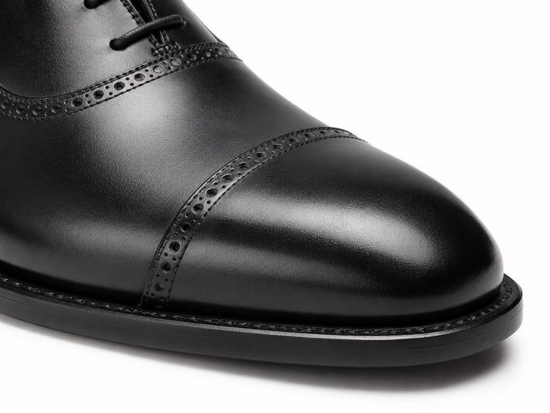 Men’s black cap toe Oxford shoes with structured toe seam, traditional lacing and sophisticated business dress shoe styling.