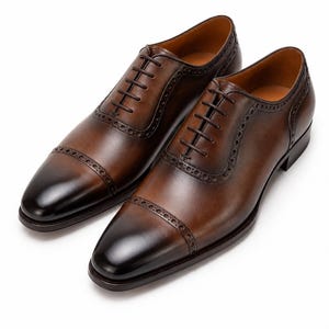 Handmade brown leather Oxford dress shoes with cap toe, closed lacing and elegant low heel.