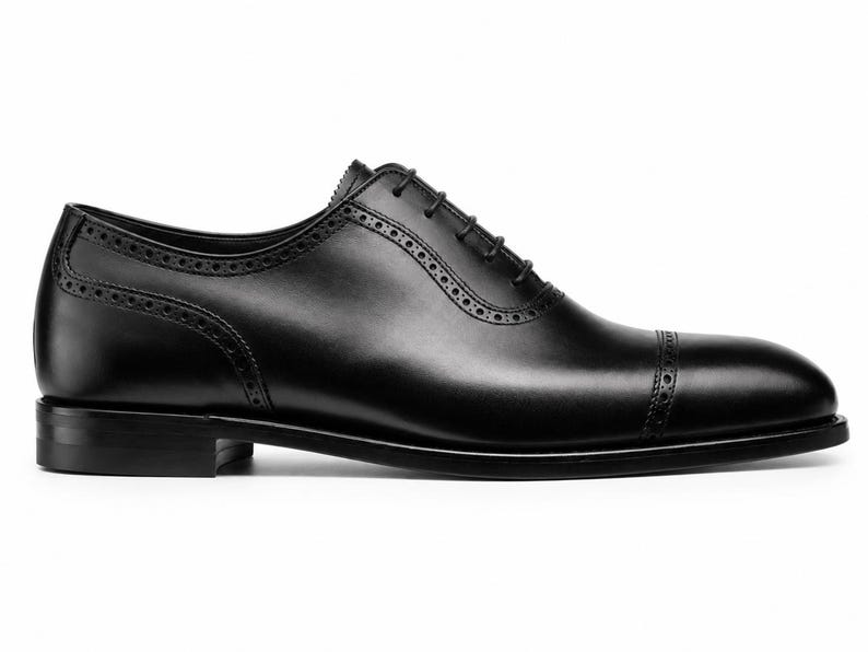 Black leather Oxford dress shoes for men featuring cap toe design, clean stitching, lace-up closure and elegant formal profile.