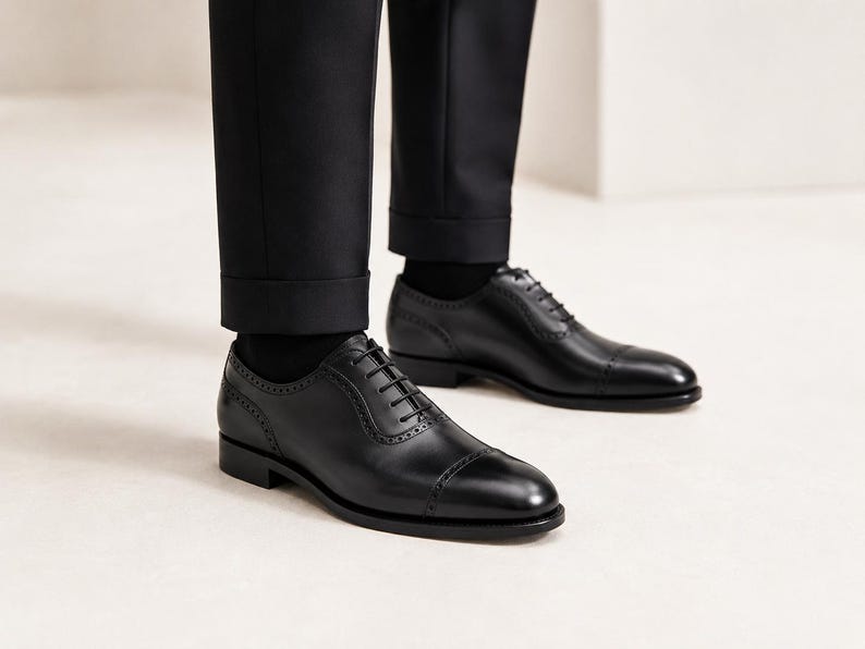 Model wearing men’s black cap toe Oxford shoes with tailored trousers for weddings, business meetings, office wear and formal events.