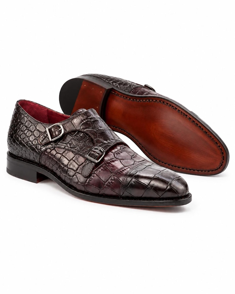 Men’s dark chocolate brown double monk strap shoes showing stitched leather outsole, stacked heel and croc embossed leather upper.