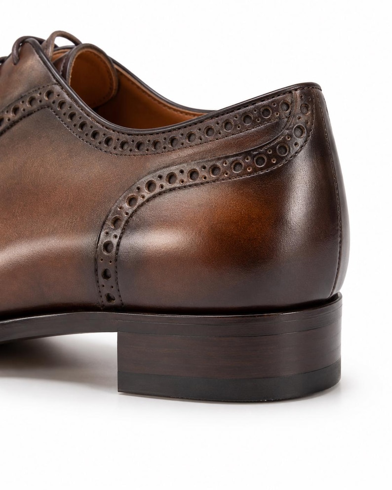 Close-up of rich brown patina leather, hand-burnished shading and detailed stitching on handmade men’s dress shoes.