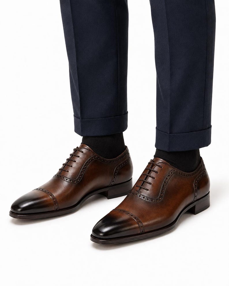 Man wearing brown leather cap toe Oxford shoes with tailored trousers for wedding, business, office and formal styling.