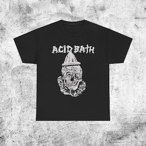 Puede incluir: Una camiseta negra de manga corta con un estampado gráfico blanco de una calavera con un sombrero de payaso puntiagudo y un cuello con volantes. El texto ACID BATH está impreso en una fuente blanca desgastada sobre la calavera.