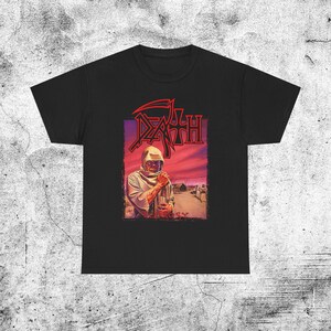 Może przedstawiać: Czarny t-shirt z krótkim rękawem z nadrukiem graficznym okładki albumu Leprosy zespołu Death. Wzór przedstawia postać w kapturze na tle pustynnego krajobrazu pod czerwonym niebem, z napisem DEATH czerwoną czcionką powyżej i LEPROSY poniżej.