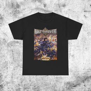 May include: A black short-sleeve t-shirt featuring a graphic print on the chest. The print displays the text BOLT THROWER at the top and REALM OF CHAOS at the bottom, surrounding a detailed battle scene with soldiers, weaponry, and fire.