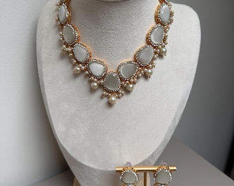 Elegant gold-tone jewellery set featuring ivory white stones, sparkling crystal accents, and pearl detailing.