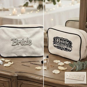 May include: Two off-white canvas zipper pouches with black trim. One pouch features the word Bride in raised grey lettering. The other pouch displays a black graphic label reading Bride Emergency Survival Kit. A small tag reads Handcrafted for the Bride.