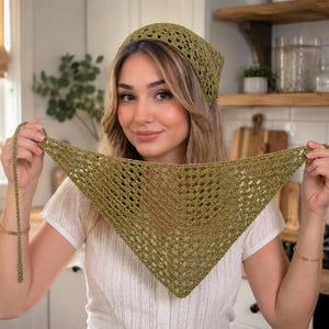 May include: An olive green crochet headscarf featuring an openwork diamond pattern. The triangular accessory is crafted with a textured yarn and includes long, thin ties at each end for securing the piece around the head or hair.