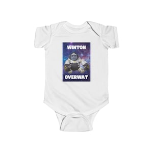 May include: White baby bodysuit with a graphic featuring a cartoon gorilla character against a galaxy background. The text "WINTON OVERWAT" is displayed above and below the character. The bodysuit is made of soft fabric.