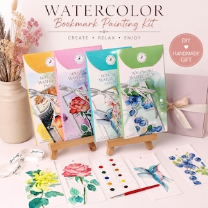 May include: A watercolor bookmark painting kit featuring four rectangular packages in yellow, pink, blue, and green. Each package displays a floral or bird illustration, a ribbon, and the text "HOLLOW OUT WATERCOLOR PAINTING". Includes a paint palette and brush.