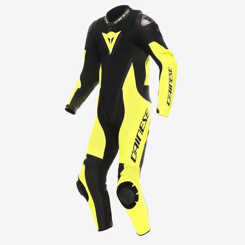 May include: Black and neon yellow motorcycle racing suit. The suit features the Dainese logo on the chest, arms, and legs. The suit has protective padding on the shoulders, elbows, knees, and back. The suit is designed for safety and performance.