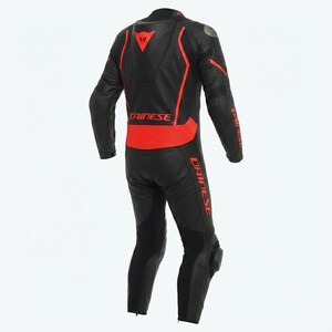 Puede incluir: Traje de carreras de motociclismo negro y rojo. El traje presenta una base negra con detalles rojos en los hombros, la espalda y las piernas. El logotipo de Dainese es visible en la espalda y los brazos. Acolchado protector en rodillas y codos.