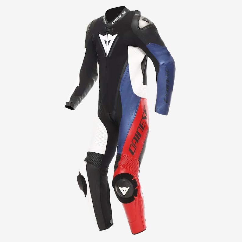 May include: A multi-coloured motorcycle racing suit in black, white, blue, and red. The suit features a white logo on the chest and the word "DAINESE" printed on the leg. It has protective padding on the shoulders and knees.