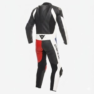 May include: A black, white, red, and blue leather motorcycle racing suit. The suit has white detailing on the arms and legs, with red and blue panels on the lower section. The Dainese logo is visible on the leg.