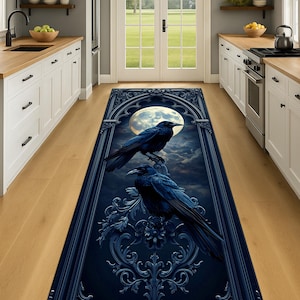 May include: A dark blue rectangular rug featuring two black crows perched on an ornate, gothic-style frame. The background depicts a full moon and a cloudy night sky. The rug is designed for indoor use.