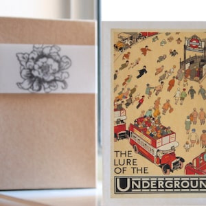 May include: Vintage postcard featuring a colorful illustration of people walking towards a London Underground station. The text reads "The Lure of the Underground".