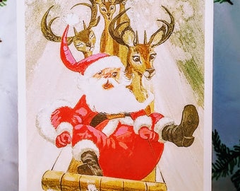 Christmas Card with Santa and Reindeer on a Tobaggan