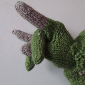 Op de afbeelding: Groene en grijze gebreide vingerloze handschoenen met een gerimpelde manchet. De handschoenen zijn gemaakt van een zacht, getextureerd garen.