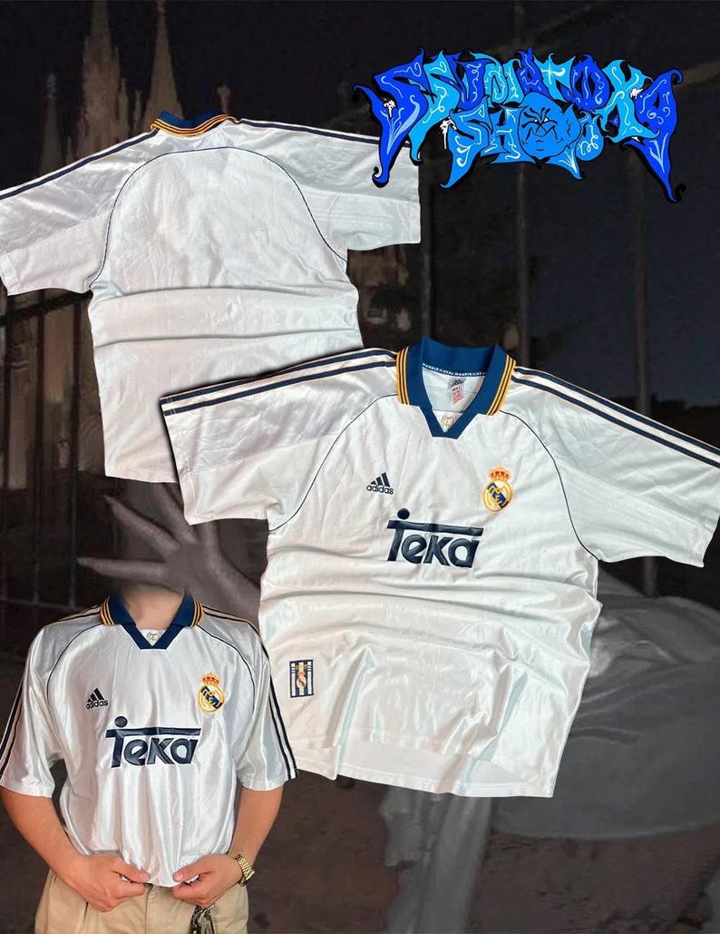 May include: White soccer jersey with blue and yellow trim, featuring the Adidas logo and "Teka" text. The jersey has short sleeves and a V-neck collar. A crest is visible on the chest. The jersey is likely vintage.