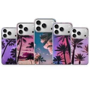 以下が含まれることがあります： ヤシの木のトロピカルなデザインの携帯電話ケース5つ。ケースは、紫、ピンク、青など、さまざまな夕焼けの色を特徴としています。ヤシの木は、カラフルな空を背景にシルエットになっています。