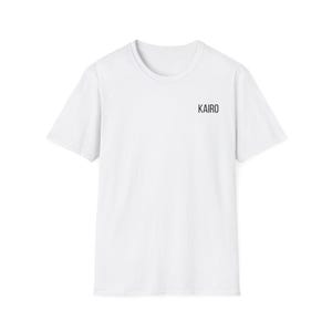 Peut inclure: Un t-shirt blanc à col rond avec le mot "KAIRO" imprimé en noir sur le haut de la poitrine. Le t-shirt à manches courtes est fait d'une matière douce et opaque.