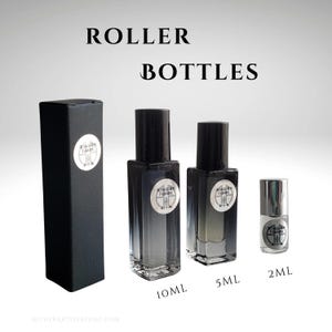 May include: Three glass roller bottles with black caps and labels. The bottles are labelled with the text "Aether Art Perfume" and the sizes are 10 ml, 5 ml, and 2 ml.