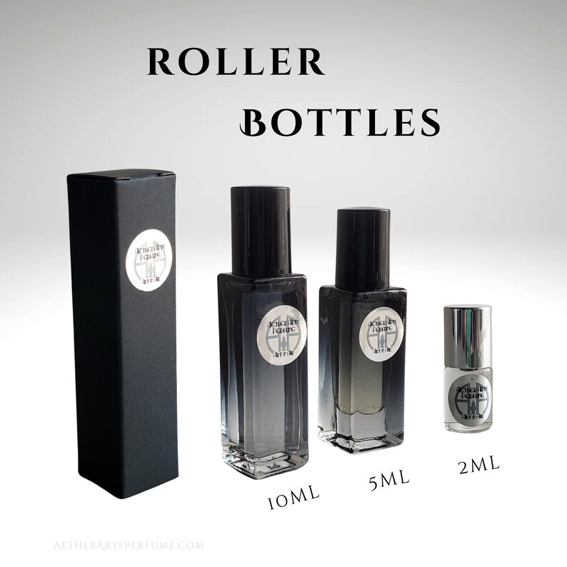 May include: Three glass roller bottles with black caps and labels. The bottles are labelled with the text "Aether Art Perfume" and the sizes are 10 ml, 5 ml, and 2 ml.